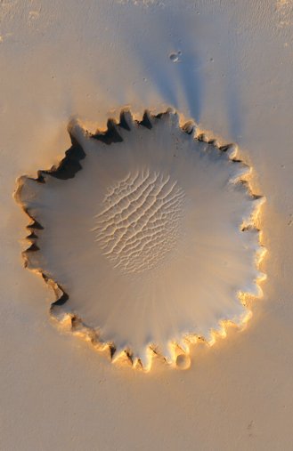The 800m diameter Victoria crater showing the unusual scalloped walls, and sief dunes on the floor. Photo by NASA. Image taken 3 October 2006 by the High Resolution Imaging Science Experiment (HiRISE).