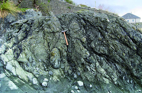 Strongly tectonised serpentinite and ophicarbonate-rock of the HBO. Innellan foreshore, Isle of Bute. The hammer shaft is 37cm long.