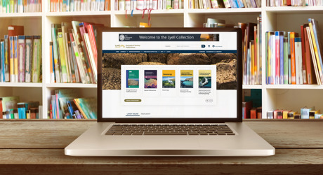 An open laptop in a library open with the Lyell page