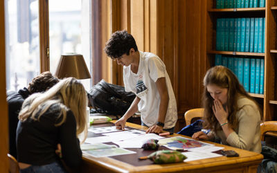 Kids looking at a map on a library table. 