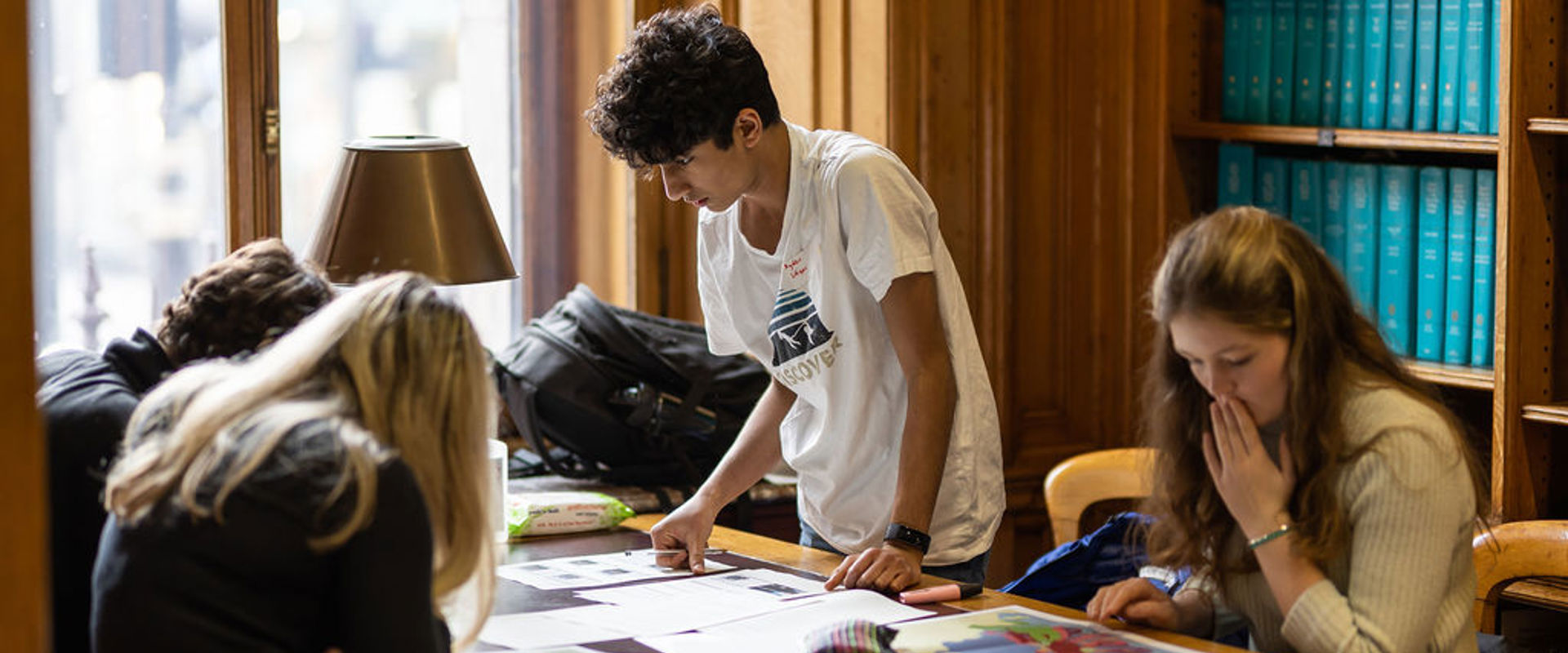 Kids looking at a map on a library table. 