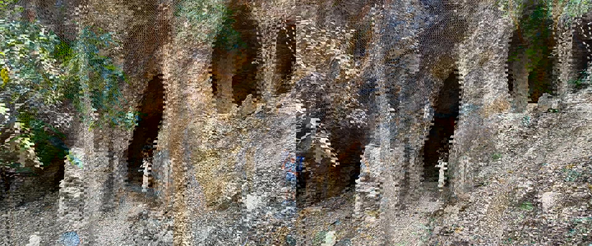 two people standing near the entrance to a mine entrance