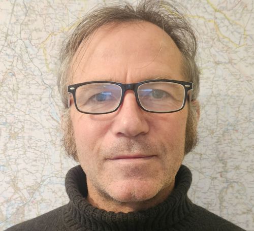 man with glasses and a polo neck jumper