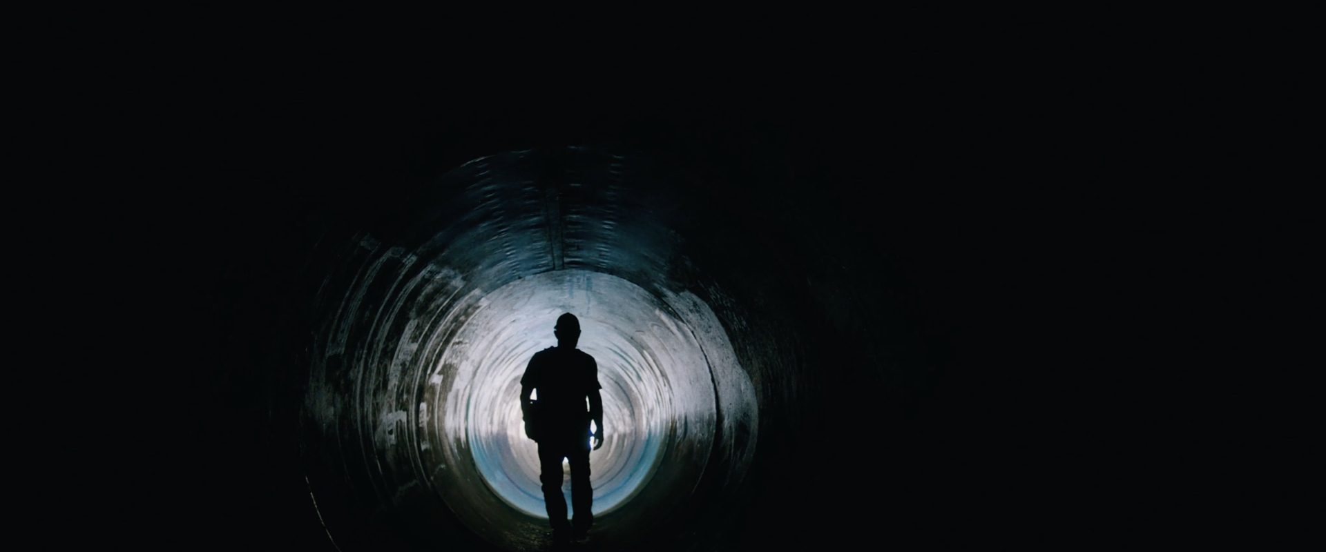Silhouette of a man walking in a tunnel