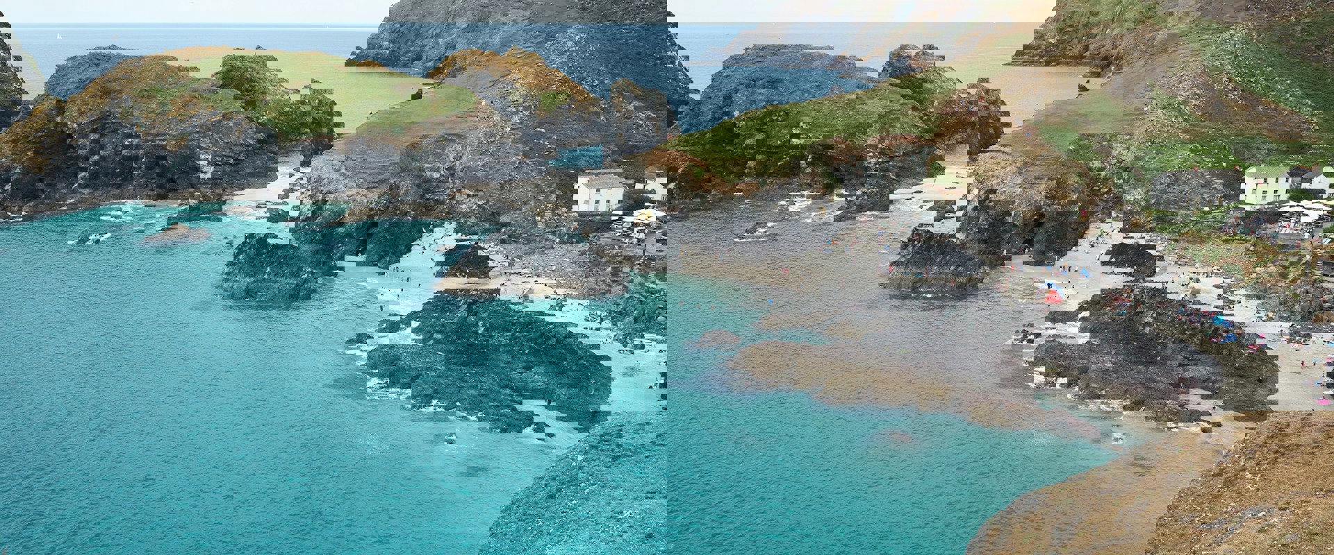 aqua blue sea waters and white sandy areas between rocky spots