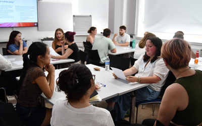 Students sitting in groups in a classroom environment chatting to each other