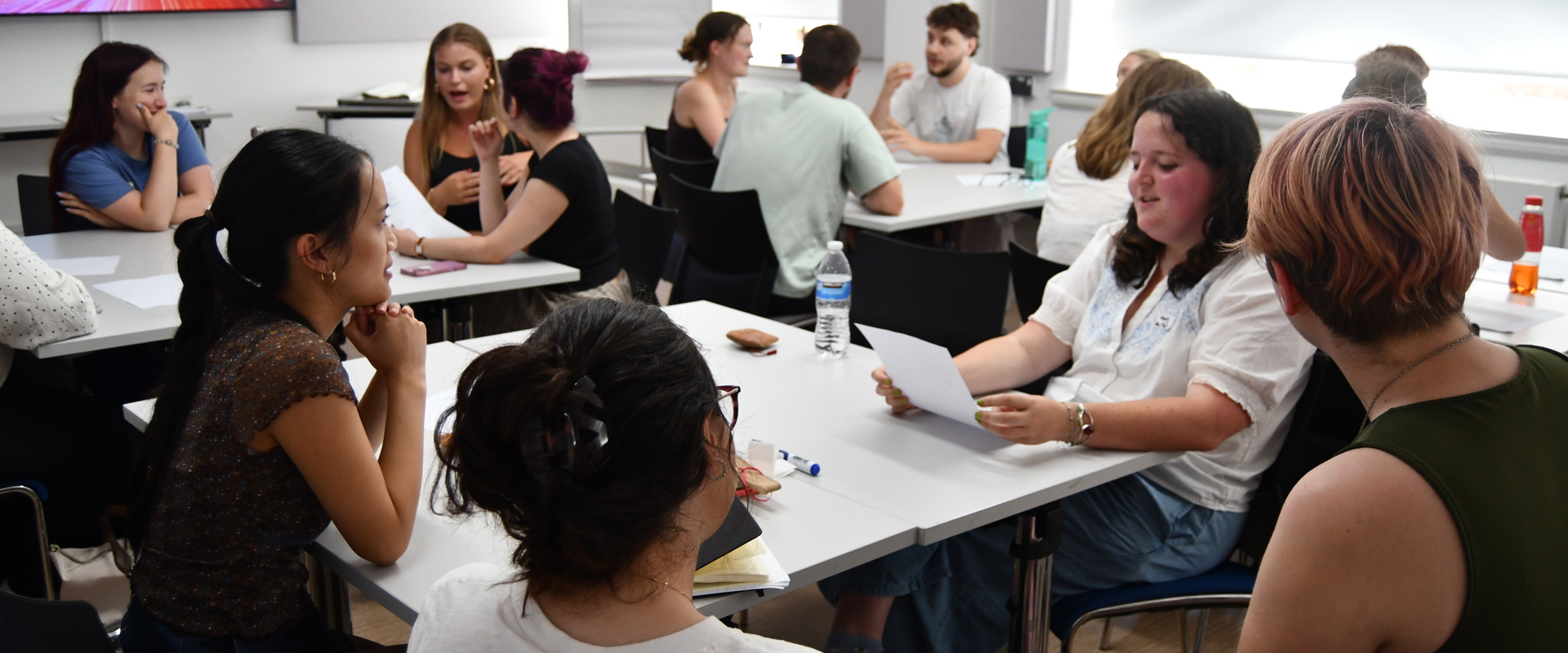 Students sitting in groups in a classroom environment chatting to each other