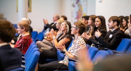 Attendees at a conference clapping in appreciation, reflecting a positive atmosphere and active participation in the event.