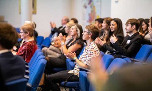 Attendees at a conference clapping in appreciation, reflecting a positive atmosphere and active participation in the event.