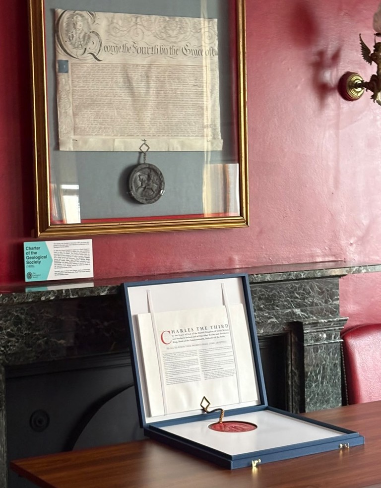 2025 Supplemental Charter sits below the framed, original 1825 Royal Charter hung on a wall 