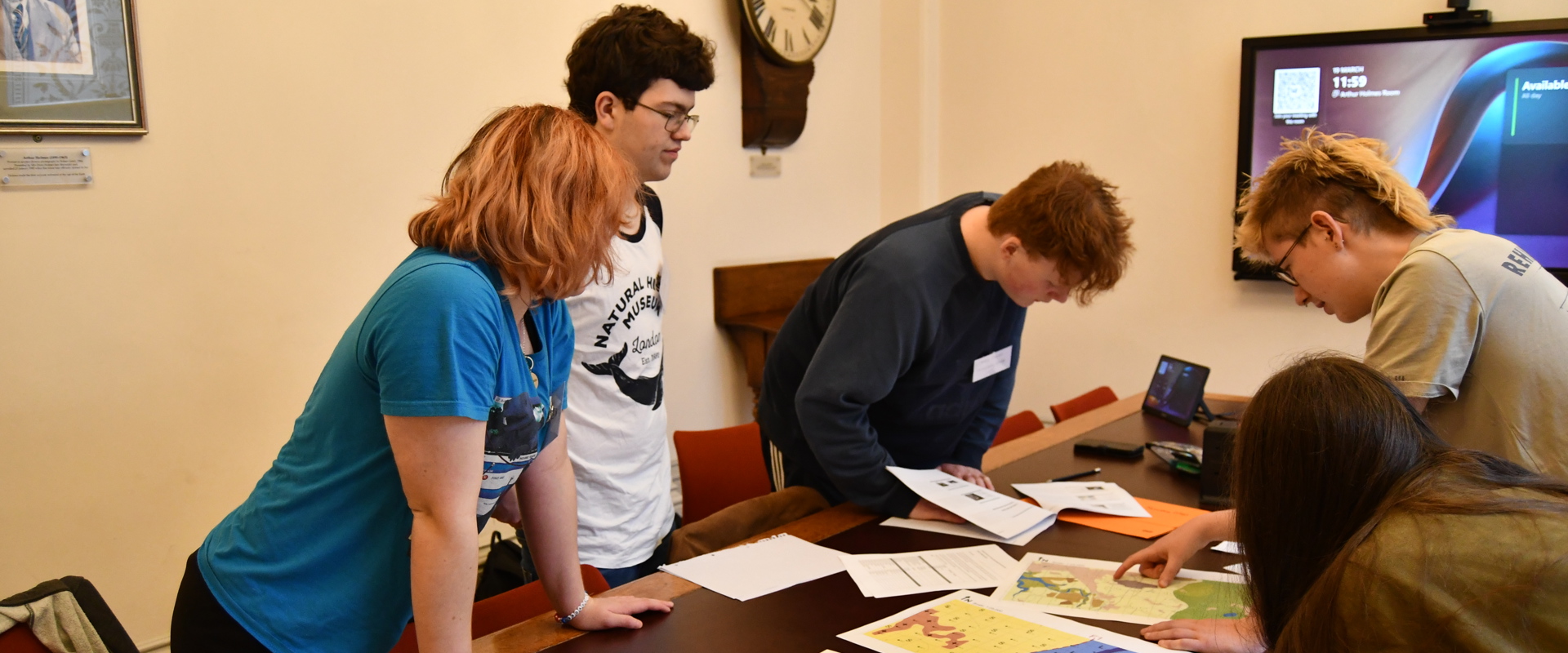 16 to 18 year olds looking at geological diagrams and maps on a desk during a team competion