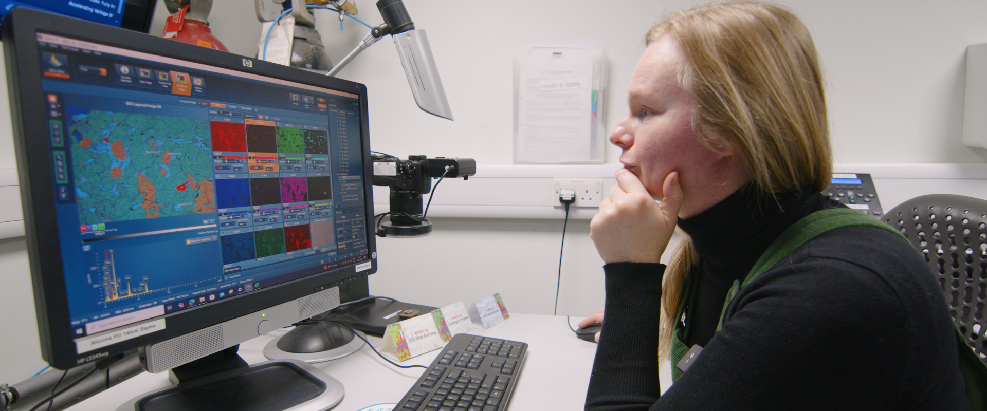A woman sits in front a computer, conducting planetary science research in a lab setting