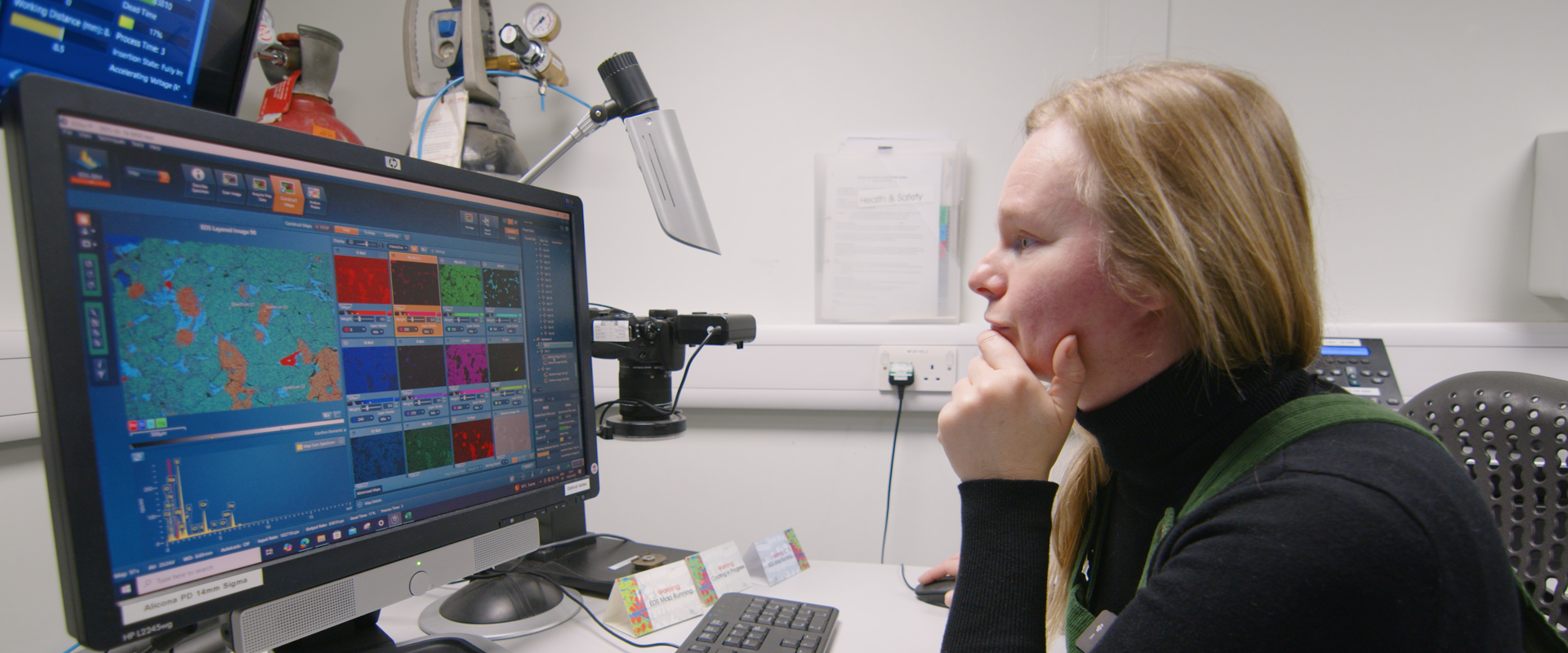 A woman sits in front a computer, conducting planetary science research in a lab setting