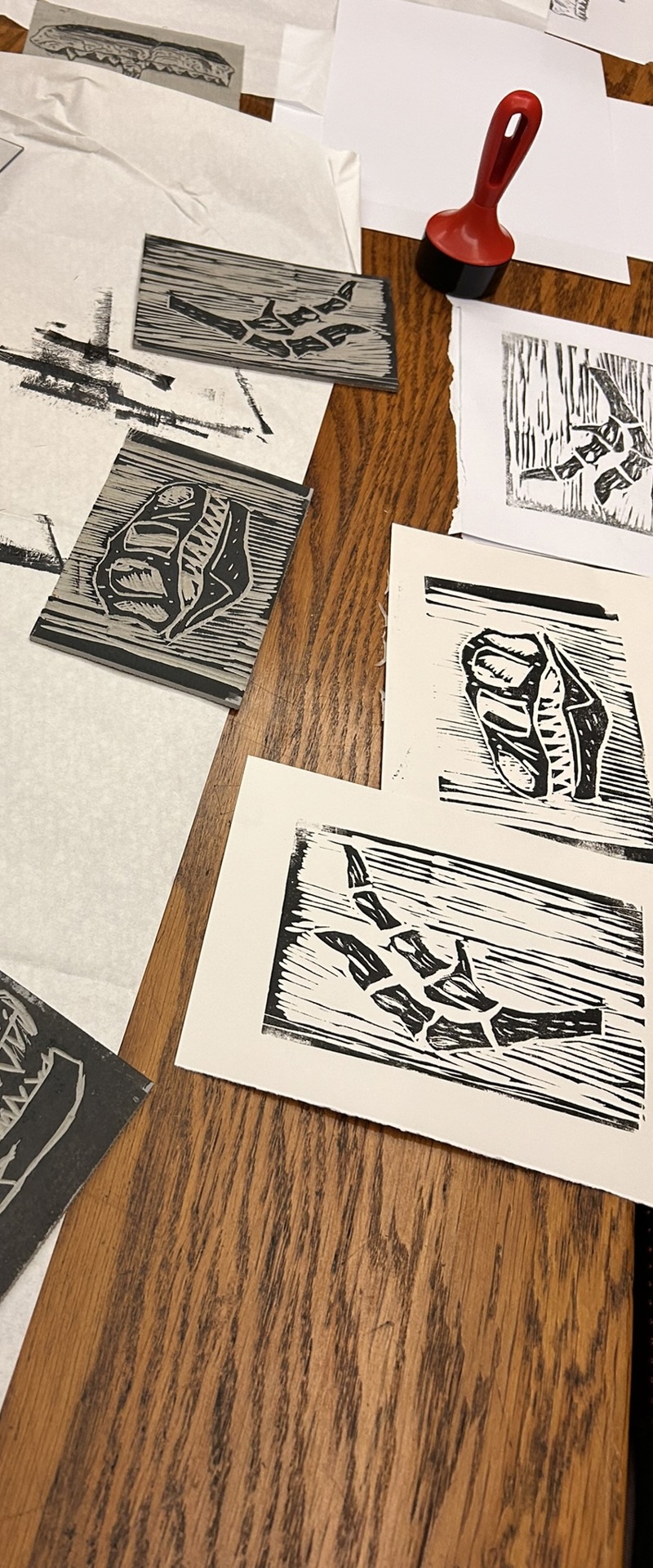 Linocut prints of dinosaurs in a table with rollers