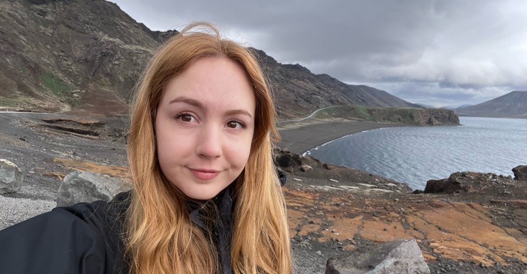young white woman with long blond hair with a mountain and lake background