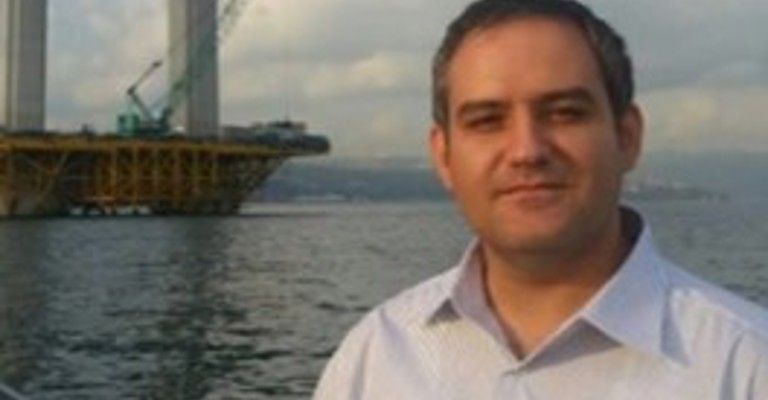 white man in front of a large boat