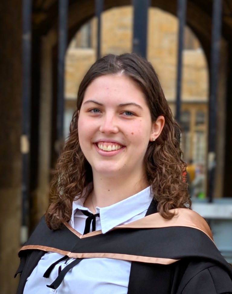 female with long dark hair and graduation clothes