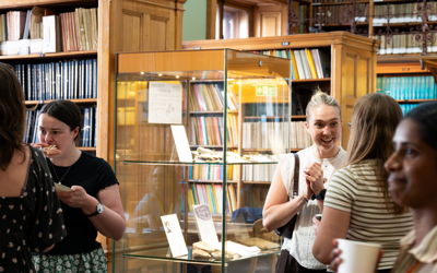 People gathered in the Geological Society library socialising and eating
