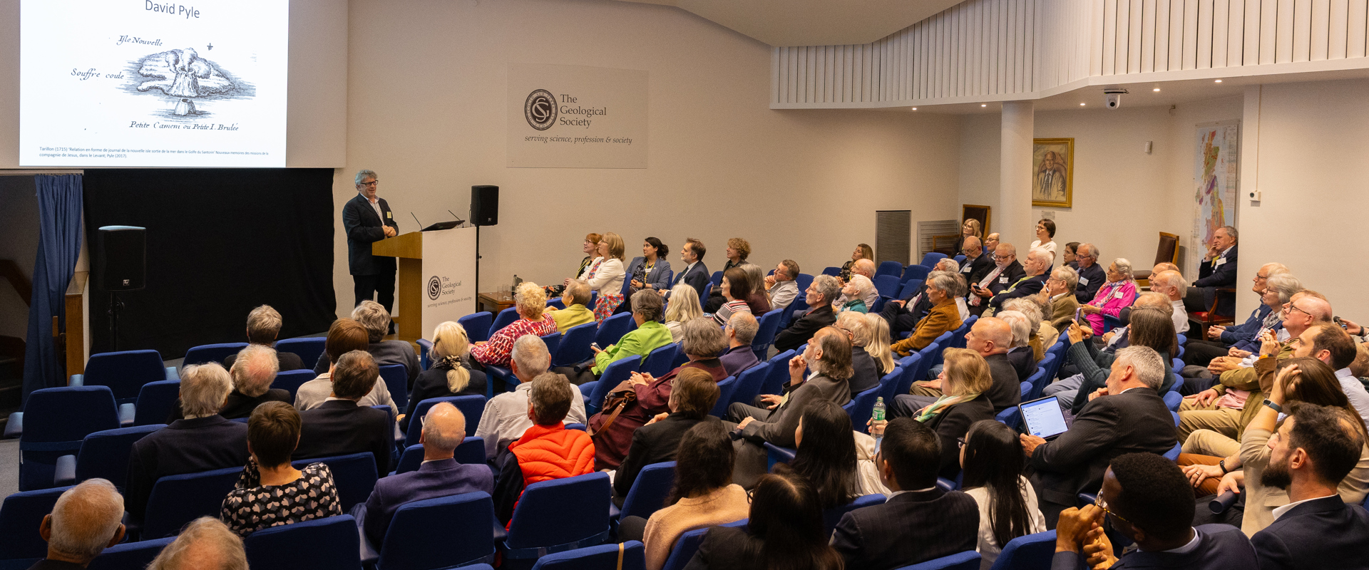 attendees seated in a lecture theatre listening to the speaker