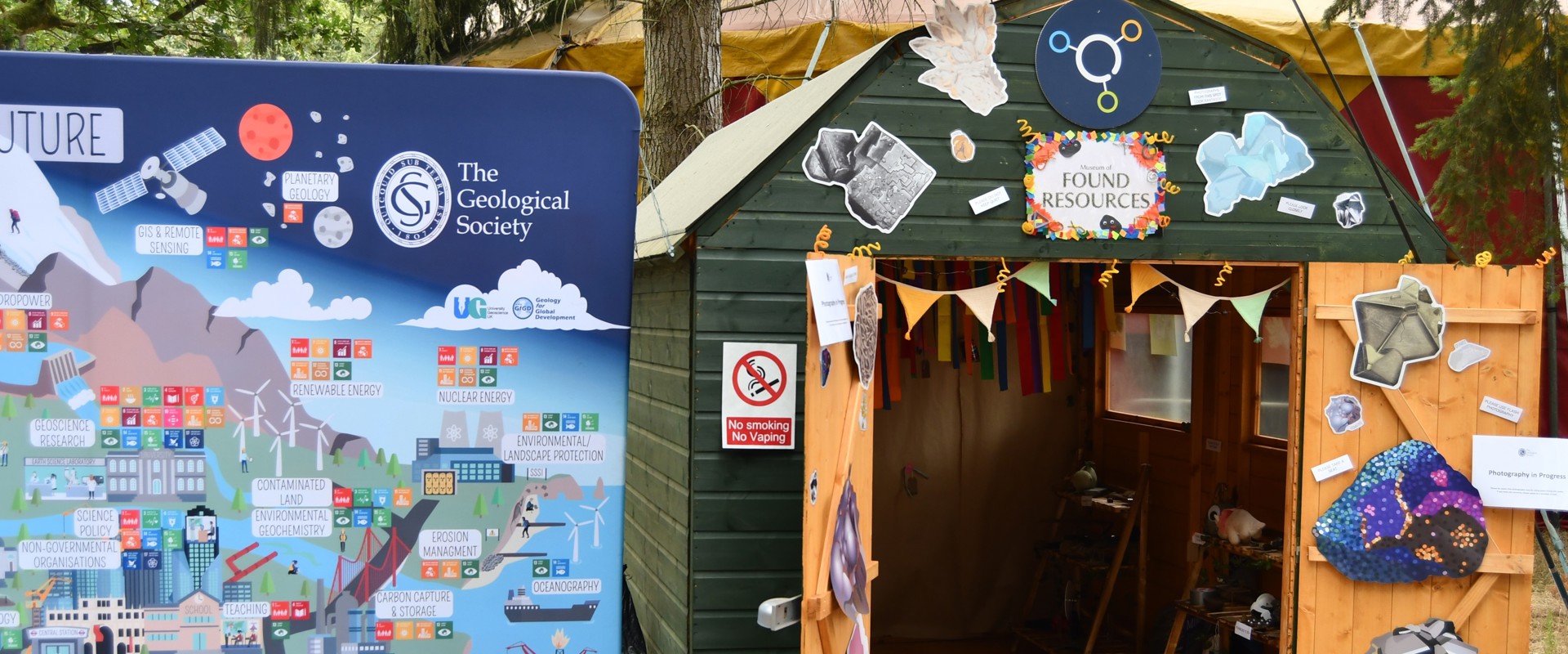 A poster about geoscience jobs stands next to a decorated shed