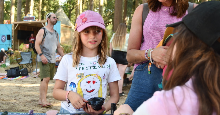 Girl holding an obsidian and talking to a science communicator
