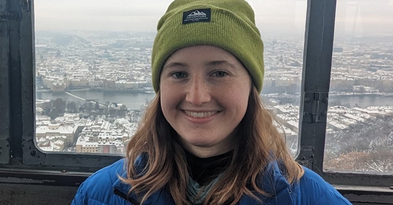 white woman with a green beanie hat on and a blue jacket