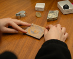 Close up of hands holding a square piece of stone