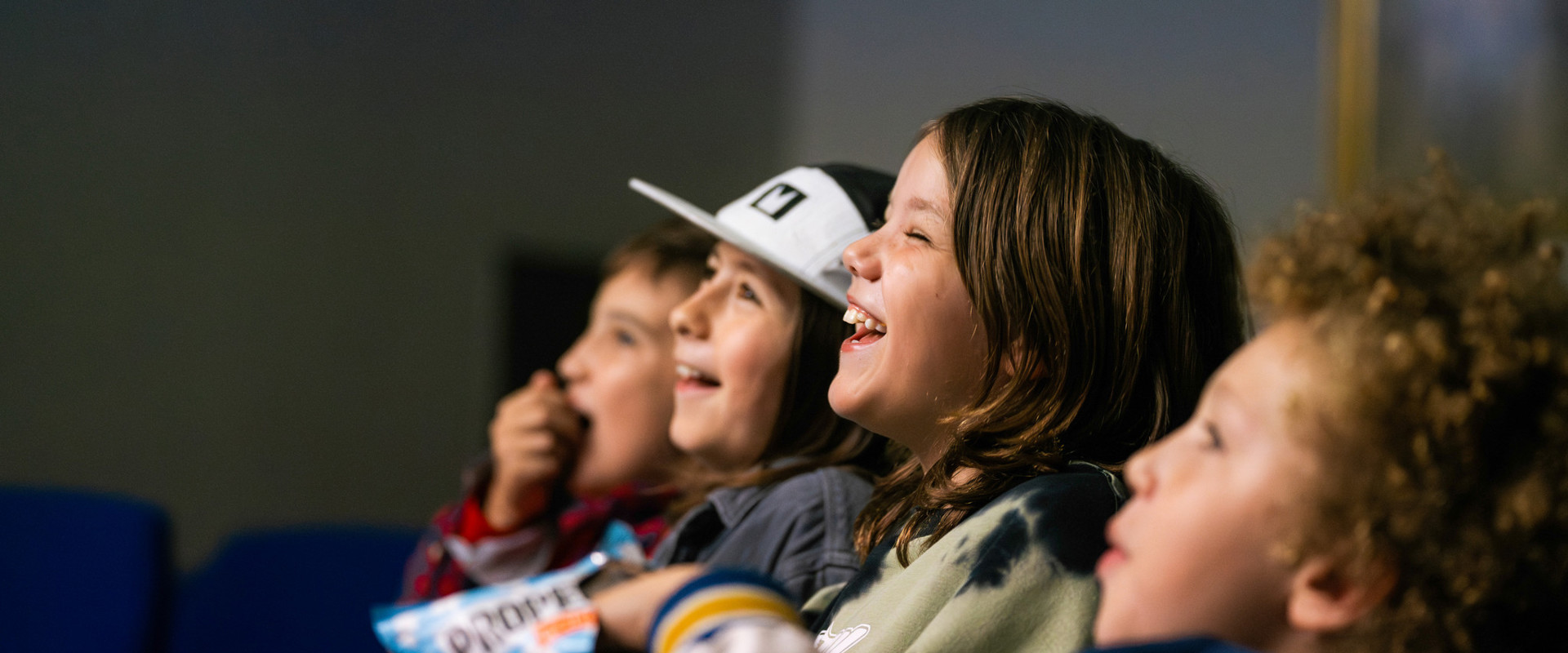 Young children laughing together and eating popcorn
