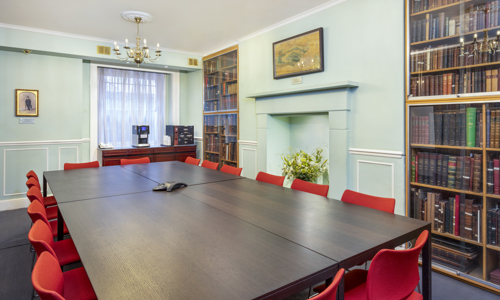 An intimate space beautifully lined with glass-covered cases of rare leather-bound books