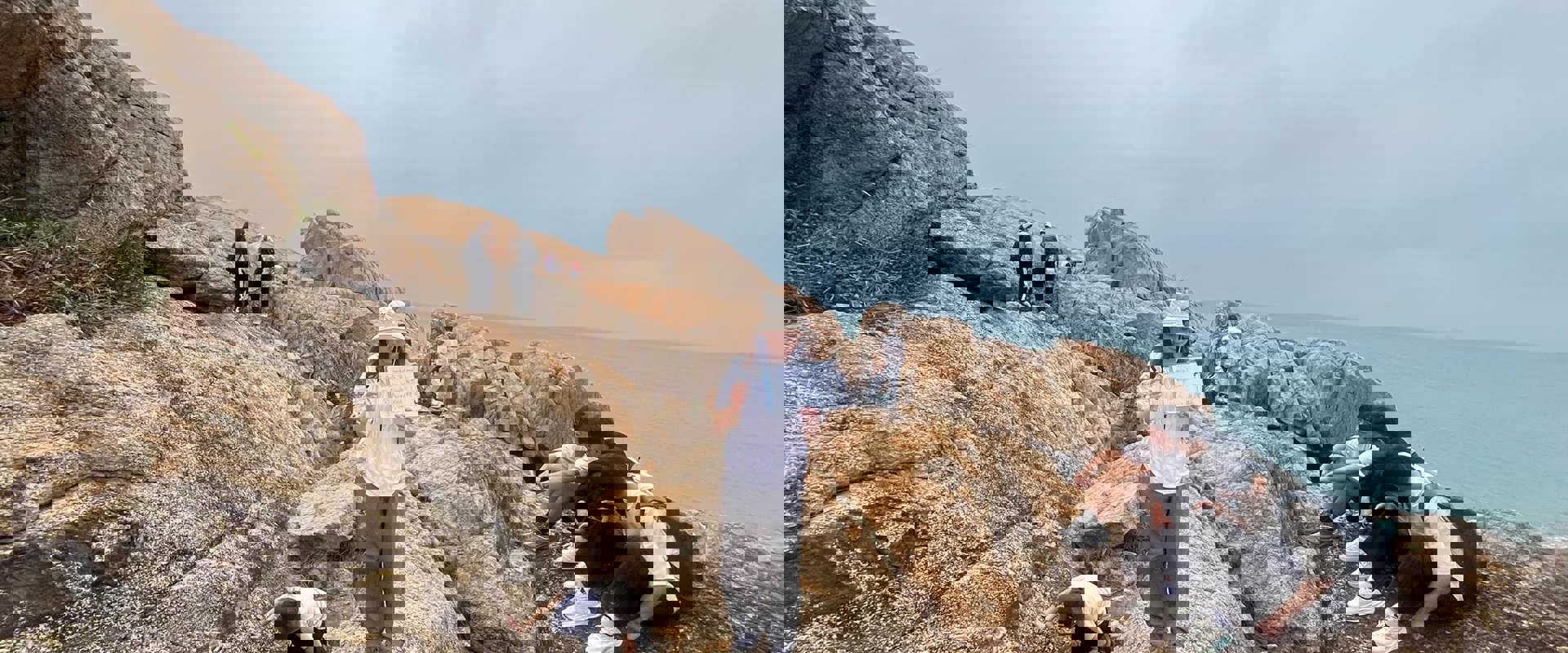 A group of people stand and sit over a rock, studying the geology of the dyke