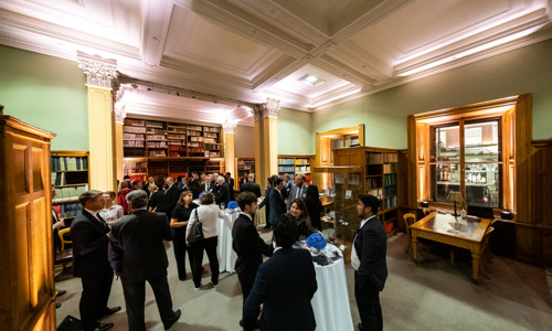 people standing at an event being held in a wood panelled library space