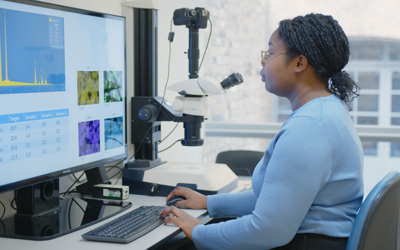A woman looks at data and samples on a computer screen