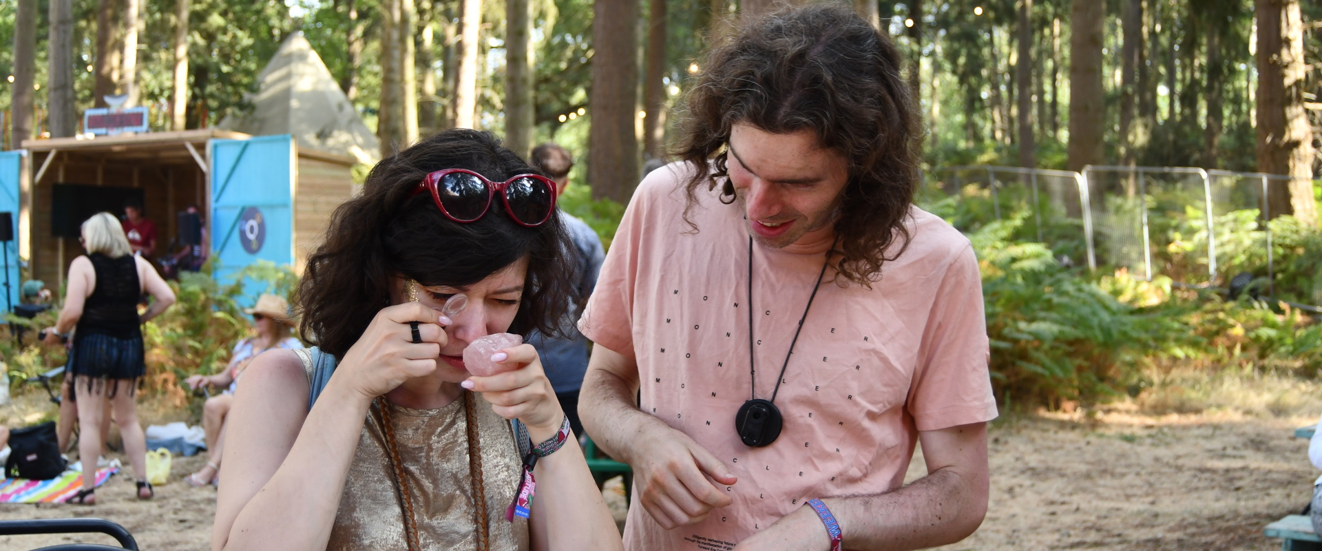 A couple inspecting a rock with a magnifying lense
