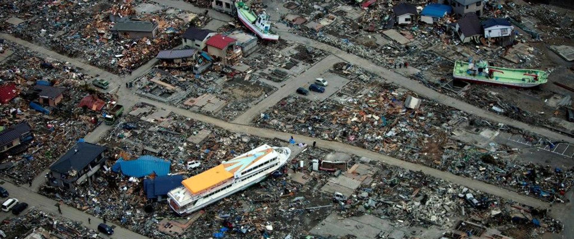 scene of devastation after a tsunami with boats on land and rubbish strewn everywhere