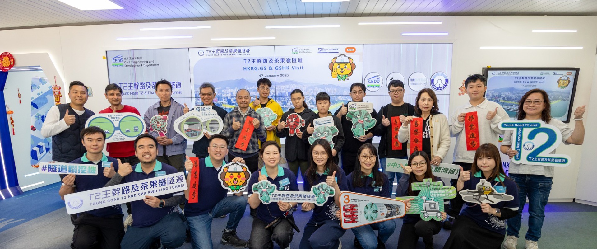a group of people from Hong Kong, stood in front of a white board, holding a variety of banners 