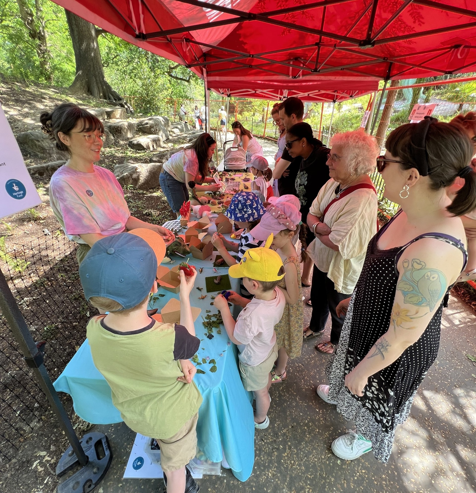 Kids and adults gathered around a long table, interacting with staff and handling fossils