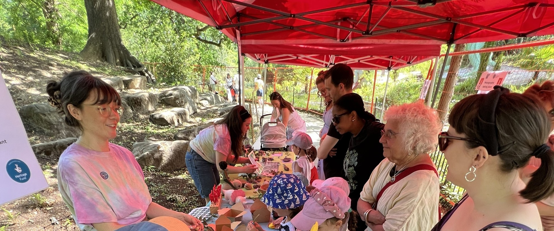 Kids and adults gathered around a long table, interacting with staff and handling fossils
