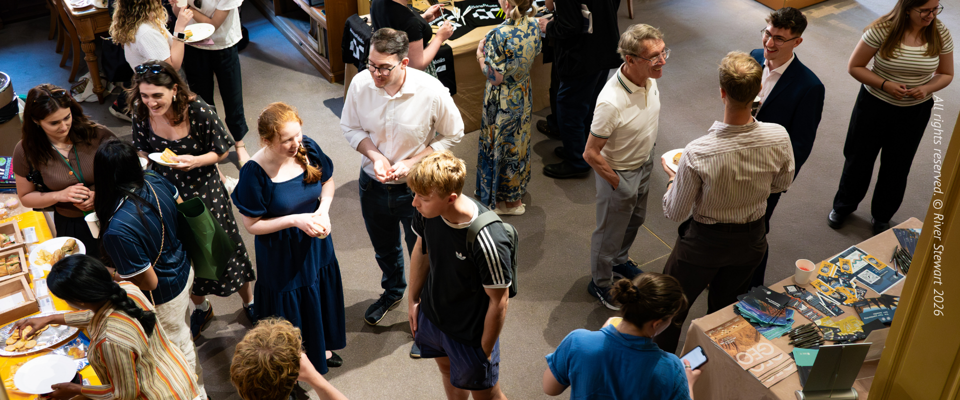 People gathered and chatting during an award ceremony in a library